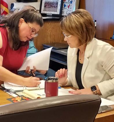 As soon as Court is adjourned, new County Judge Cindy Therwanger attends to some unfinished business with County Auditor Esmerelda Felan. (Sentinel Photo/Sam Holbrooks)
